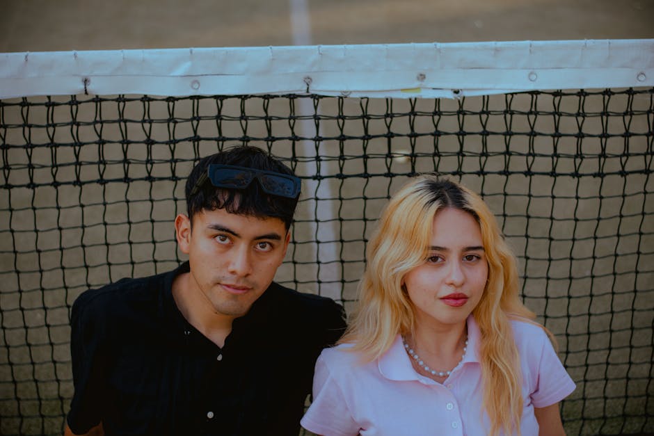 Pareja de dobles discutiendo estrategia en pista de tenis